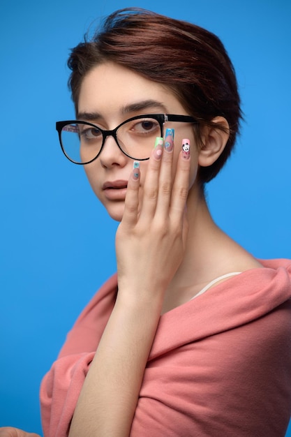 Cute female student with short haircut and extravagant nail art