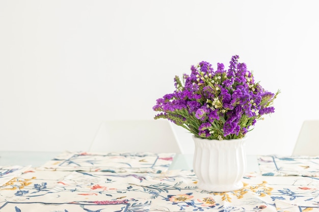 Cute flower arrangement with purple statice, decorating the dinner table