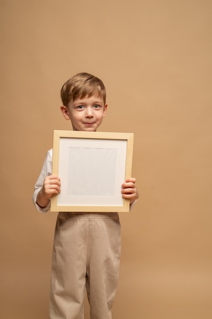 cute fouryearold blueeyed blond boy holds an empty frame in his hands