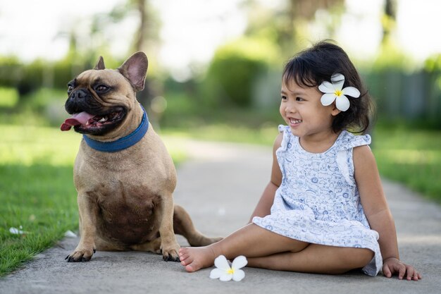 Cute french bulldog sitting with girl at park