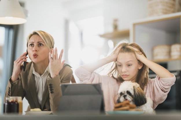 A cute frustrated teenage girl and her stressed mother in the morning at home while mom getting ready to go to work.