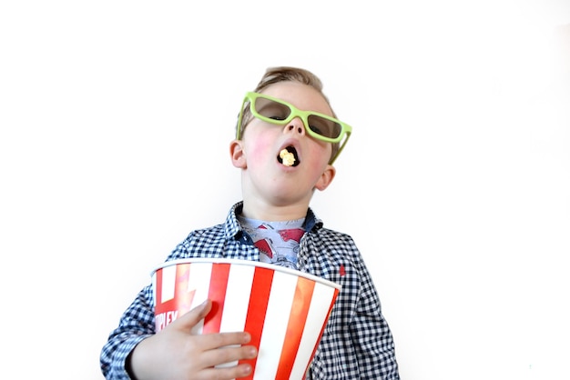 Cute fun kid baby boy 4 year old in red tshirt holding bucket for popcorn