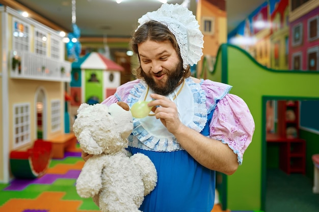 Cute funny man baby feeding teddy bear toy