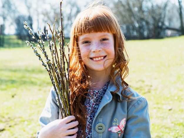 Foto ragazza sveglia dello zenzero che sorride in primavera parco