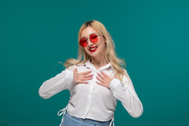 Cute girl blonde beautiful young girl in a white neat shirt confident and happy in sunglasses