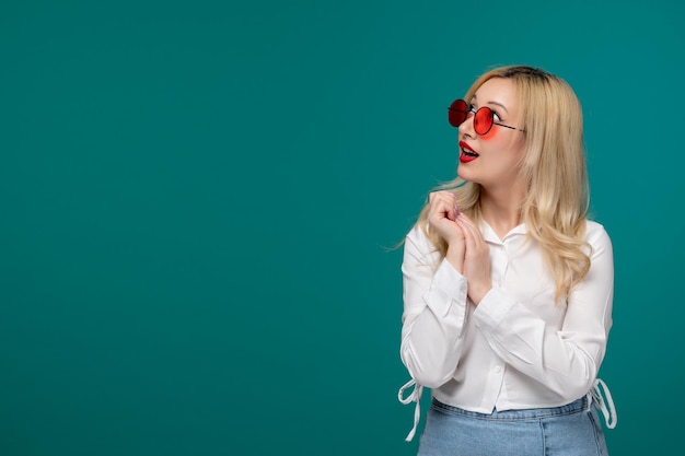 Cute girl blonde young pretty girl in a white shirt with red round sunglasses looking up