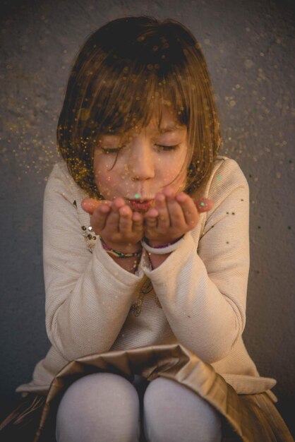 Photo cute girl blowing glitters