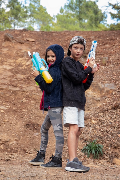 Cute girl and boy with water guns