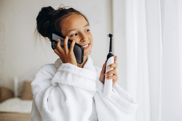 Photo cute girl brushing teeth and using phone