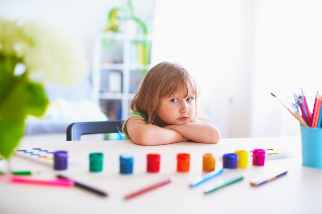 A cute girl child is waiting for permission to start drawing