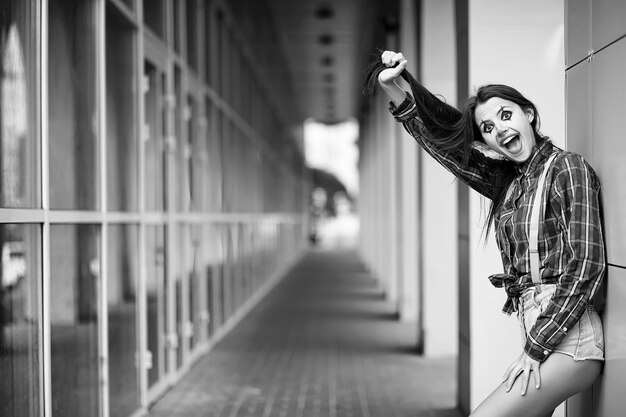 Cute girl in a clown makeup on a background black and white photo