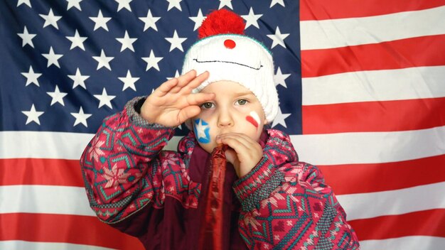 Foto ragazza carina in costume che gioca con un giocattolo contro la bandiera americana