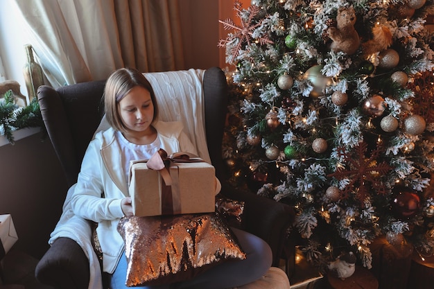 Cute girl decorates a Christmas tree. Merry Christmas and New Year Holidays.