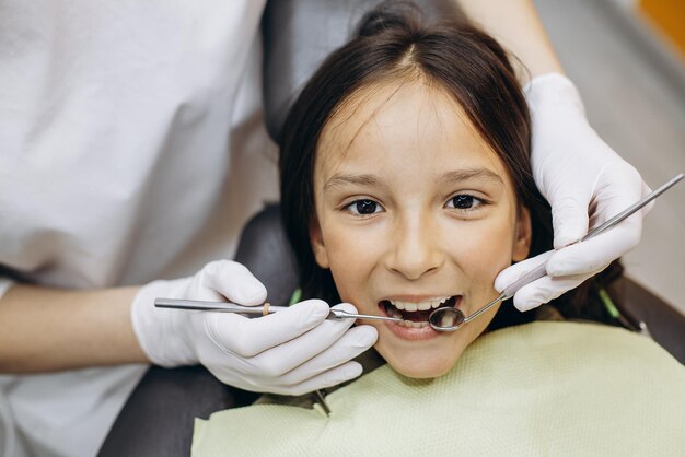 Cute girl at the dentistry chair doing checkup