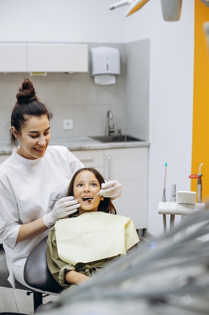Симпатичная девушка в стоматологическом кресле делает осмотр