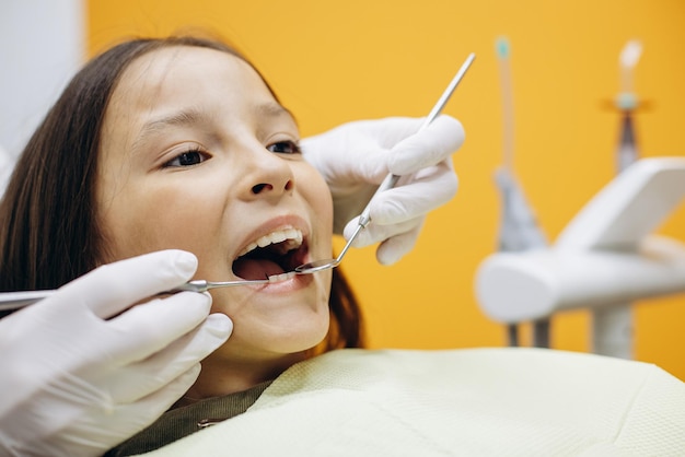 Cute girl at the dentistry chair doing checkup