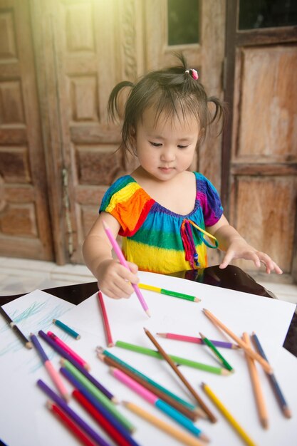 Photo cute girl drawing on paper at home