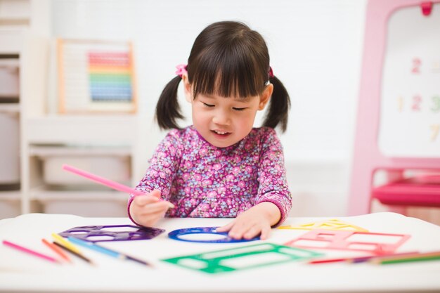 Cute girl drawing on paper at home