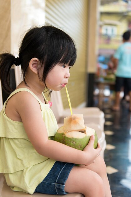 Foto ragazza carina che beve acqua di cocco