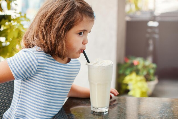 Cute girl drinking milk at home