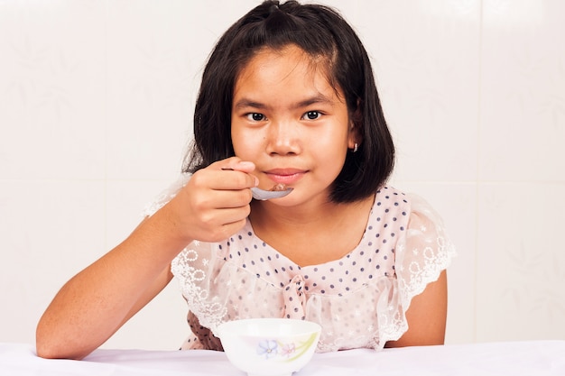 Cute girl eating breakfast cereal 