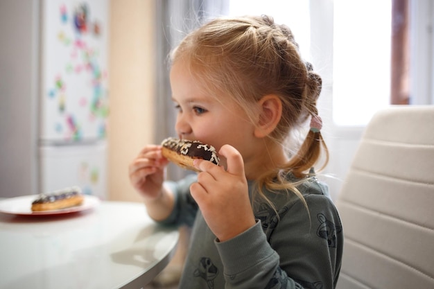 Photo cute girl eating doughnuts at home