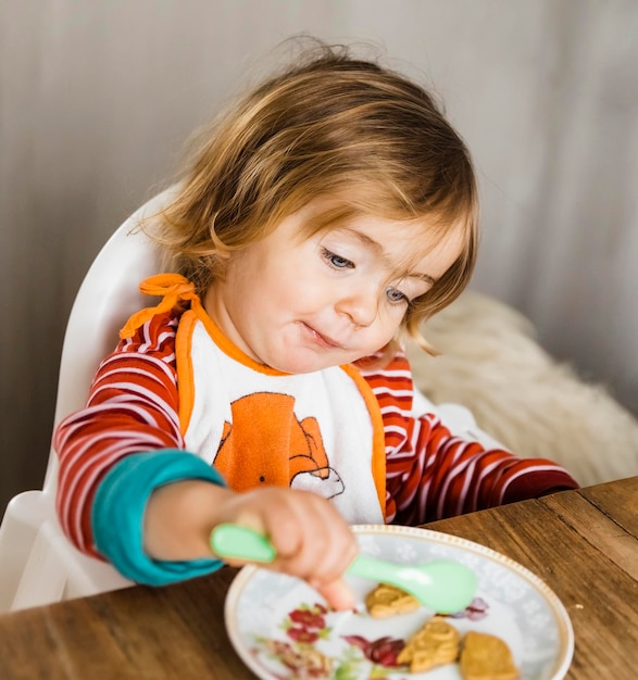 テーブルで食べ物を食べているかわいい女の子