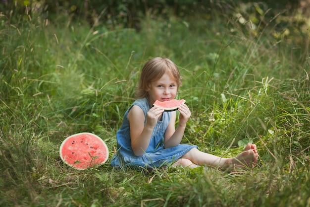 Cute girl eating watermelon in the summer outdoor Healthy snack for children