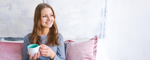 Foto una ragazza carina si gode il caffè o il tè a letto la mattina in pigiama bellissima