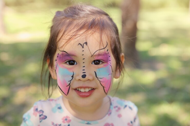 Cute girl getting face painted as a butterfly 