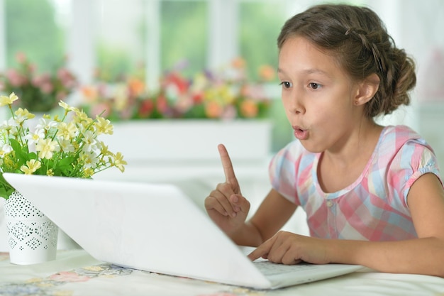 귀여운 소녀는 집에서 노트북을 사용하는 동안 아이디어가 있습니다