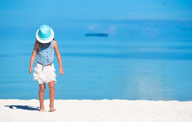 Cute girl in hat at beach during summer vacation