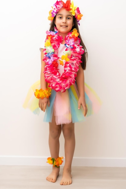 Cute girl in Hawaiian style clothes on white background