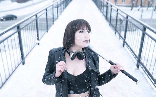 Cute girl in headphones listening to music outdoors in winter