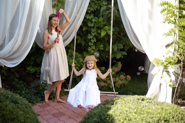 Cute girl and her mother on nature on summer walk