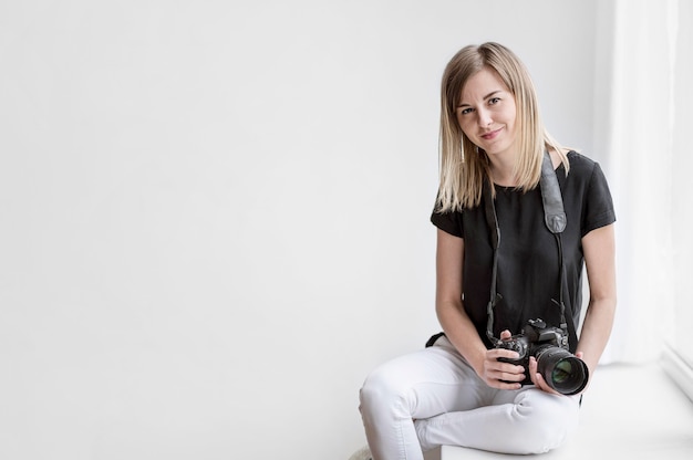 Ragazza sveglia che tiene uno spazio della copia della foto della macchina fotografica