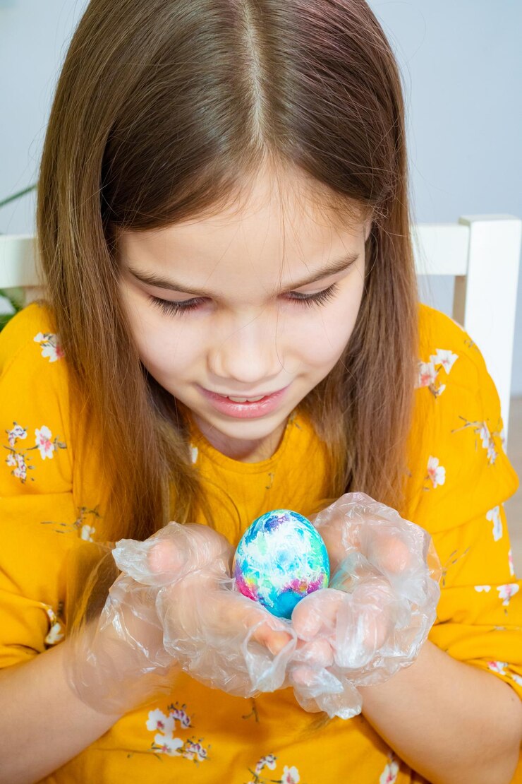 Photo cute girl holding painted egg at home
