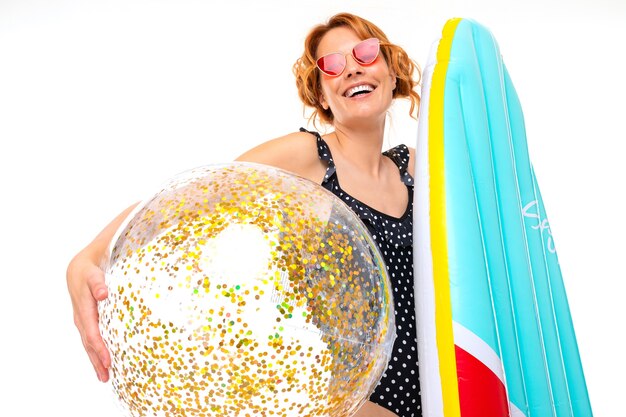 Cute girl holding a surfboard and ball with sparkles
