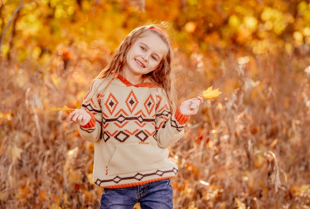 Cute girl holding yellow leaves