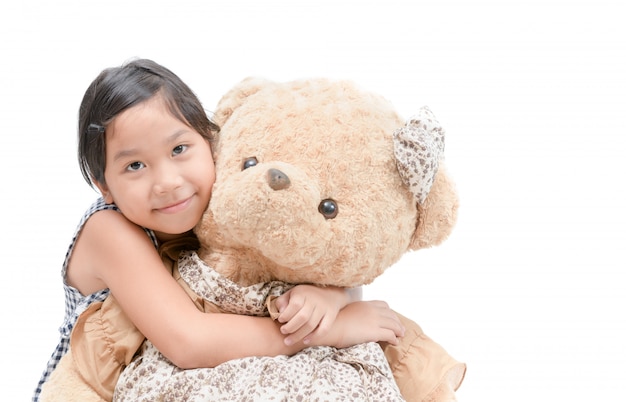 Cute girl hugging big teddy bear isolated 