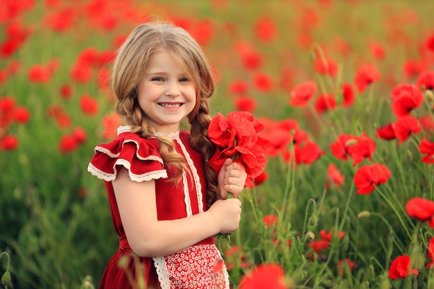 Фото Милая девушка в красном платье на маковое поле
