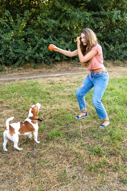 Фото Милая девушка играет со своей собакой в парке