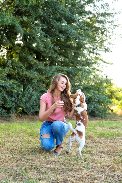 Cute girl is playing with her dog in the park