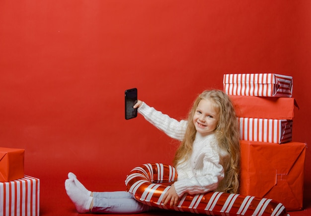 Cute girl is preparing for the new year in the background with gifts