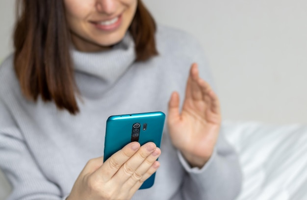 Cute girl is speaking on the mobile phone with her friends or family from far no eyes visible