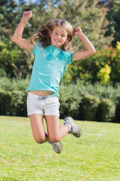 Cute girl jumping and smiling at camera