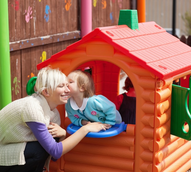 Photo cute girl kissing her smiling mother