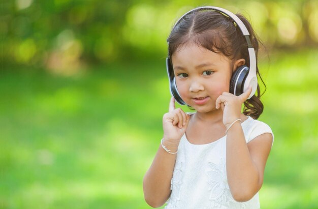 Cute girl listening to music in park