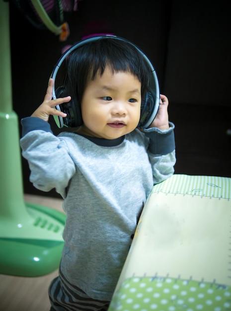 사진 집에 서서 음악을 듣는 귀여운 소녀