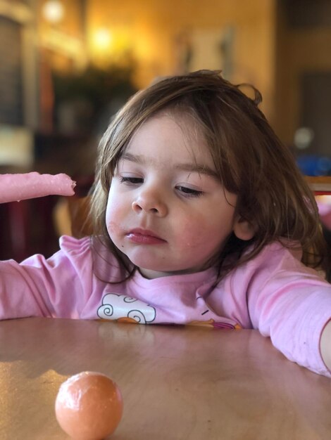 Photo cute girl looking away on table at home